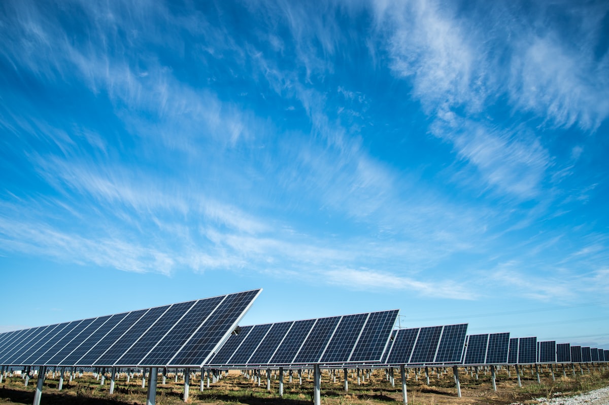 Campo de painéis solares sob céu azul