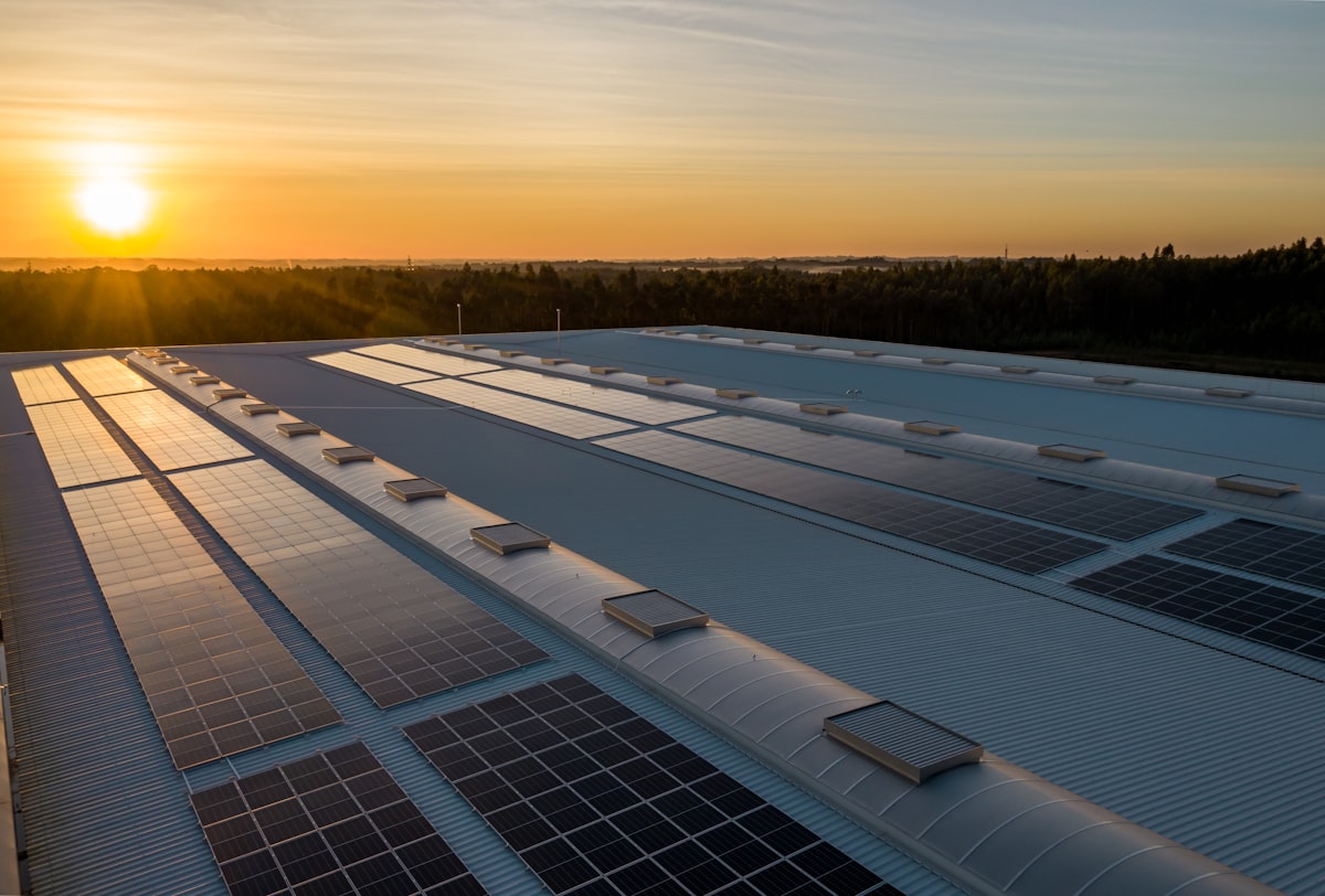 Painéis solares em telhado comercial ao pôr do sol